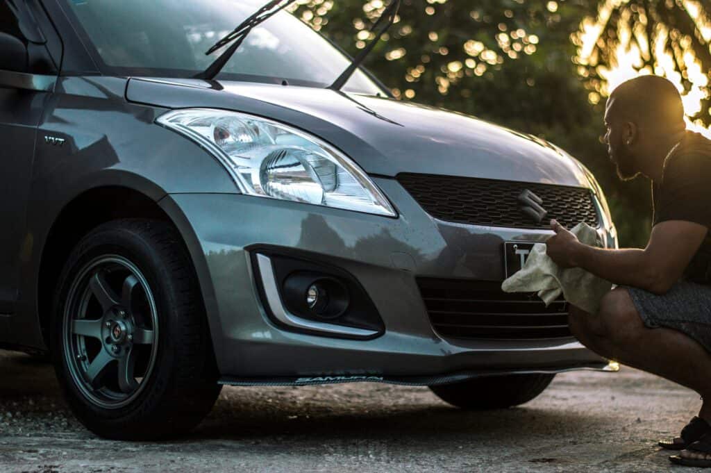 Un homme qui lave sa Suzuki Swift