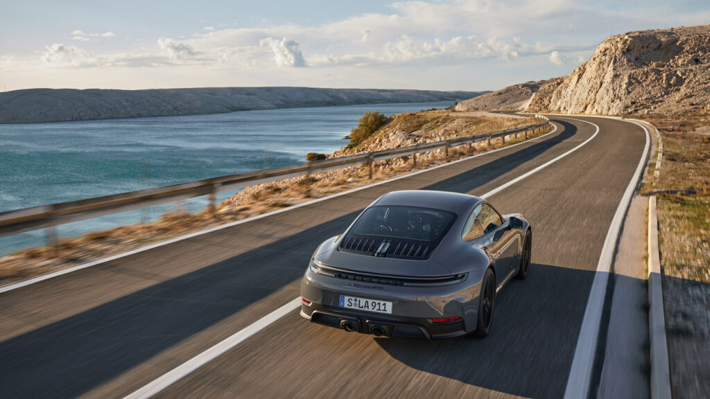 Mondial de l'auto 2024, La nouvelle 911 Carrera GTS t-hybrid, vue aérienne, arrière droite, en roulant bord de mer