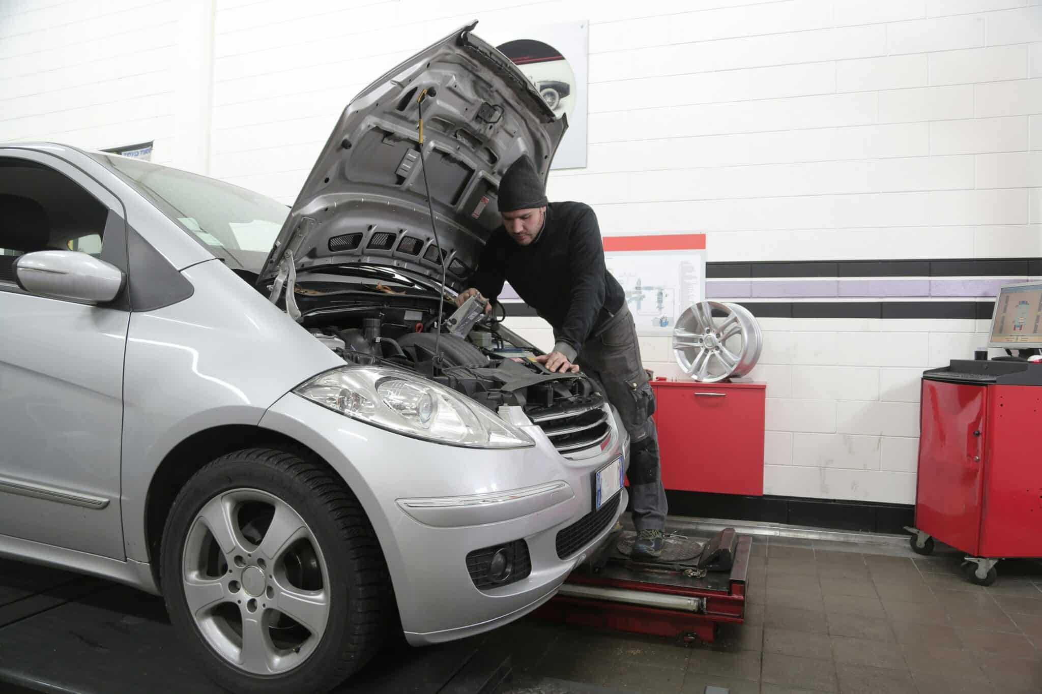 voyant moteur allumé sur le tableau de bord que dois-je faire ? Homme faisant de la mécanique dans le moteur d'une voiture - mondial de l'auto 2024