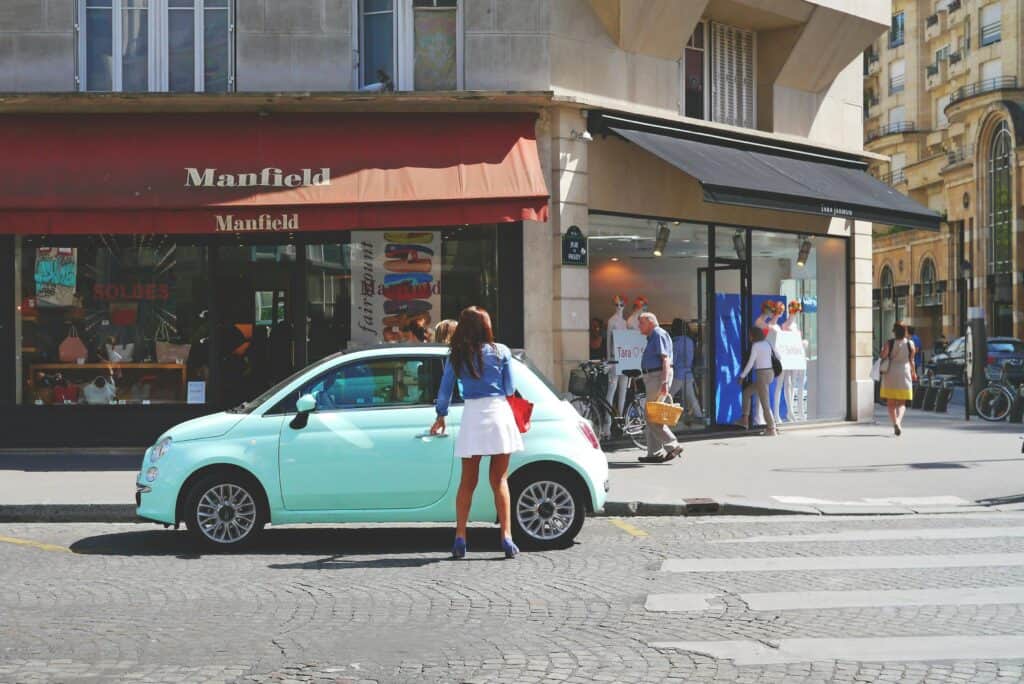 photo d'une femme qui s'apprête a entrer dans sa voiture, stationnement sur un passage piéton - mondial de l'auto 2024