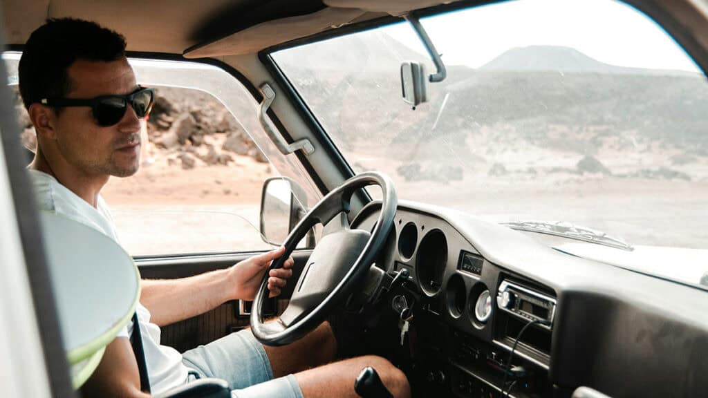 Lunettes de soleil pour la conduite - homme entrain de conduire une voiture avec des lunettes de soleil - reglementation conduite avec lunettes de soleil - mondial de l'auto 2024