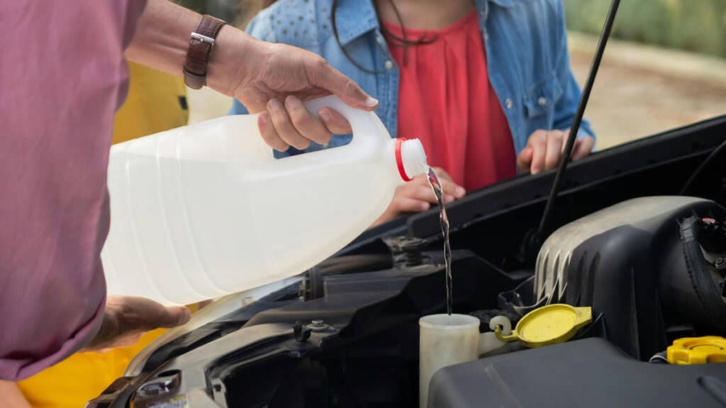 Photo d'un homme en train de verser du liquide de refroidissement dans une voiture - mondial de l'auto 2026