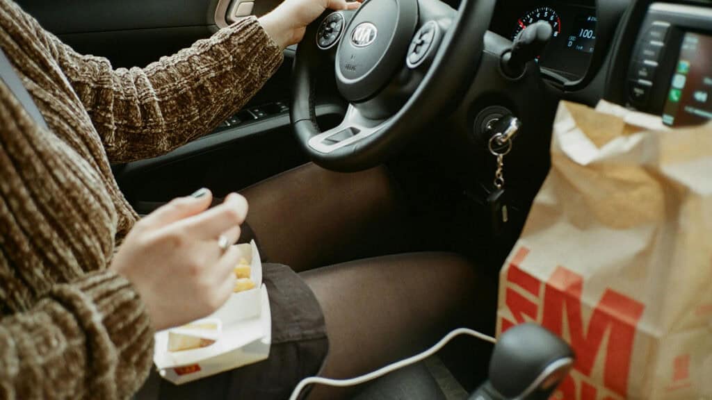 photo d'une femme entrain de manger au volant - legislation - mondial de l'auto 2026