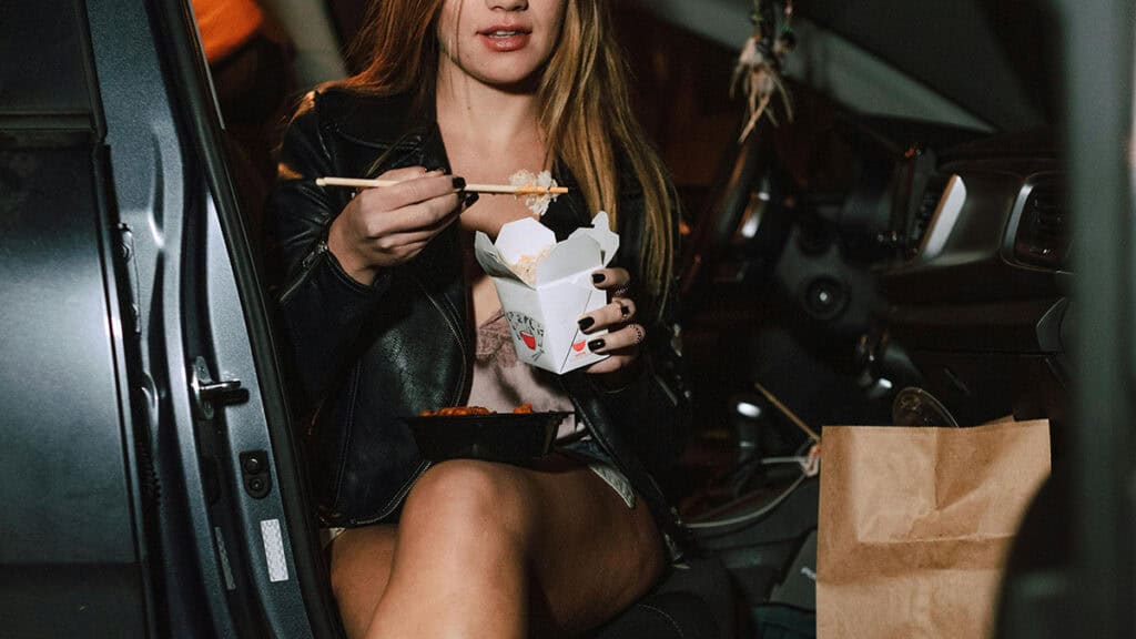 photo d'une femme entrain de manger dans la voiture - leglislation manger / boire au volant - mondial de l'auto 2026