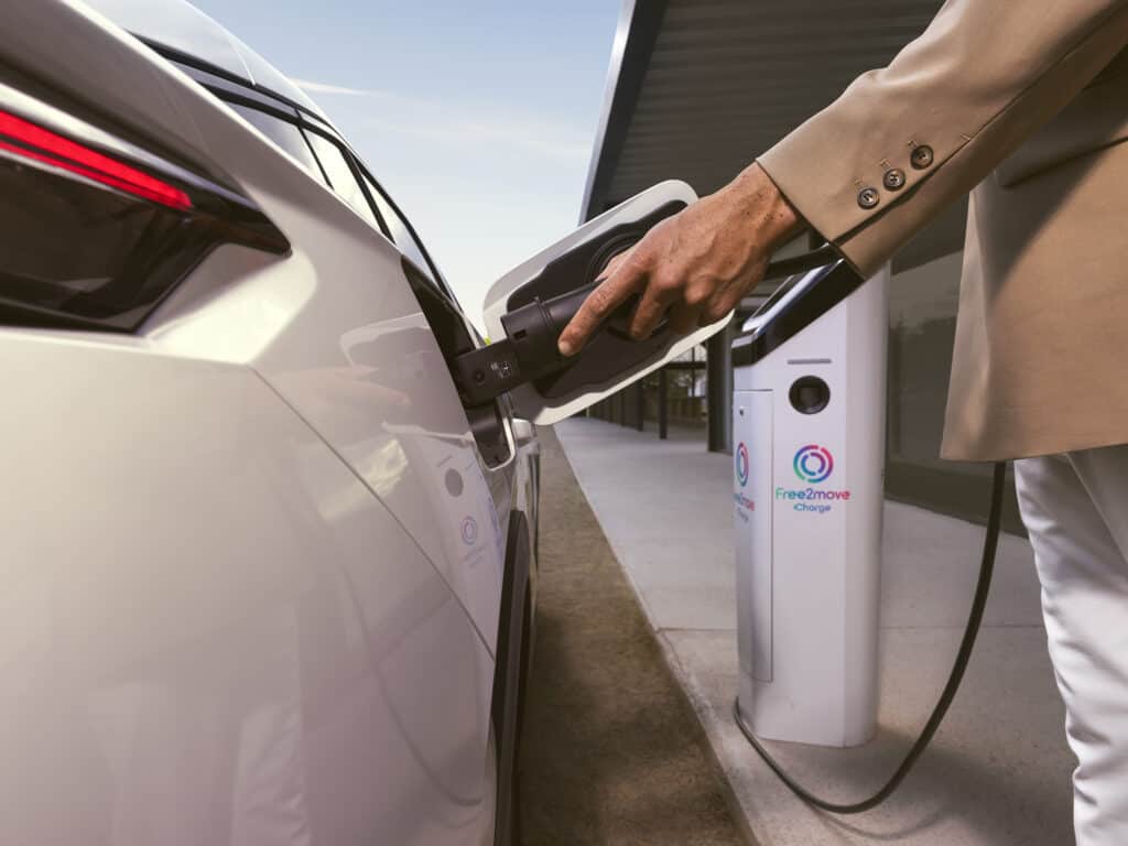 photo d'une personne entrain de recharger la voiture - peugeot 100% électrique - mondial de l'auto - voiture électrique 