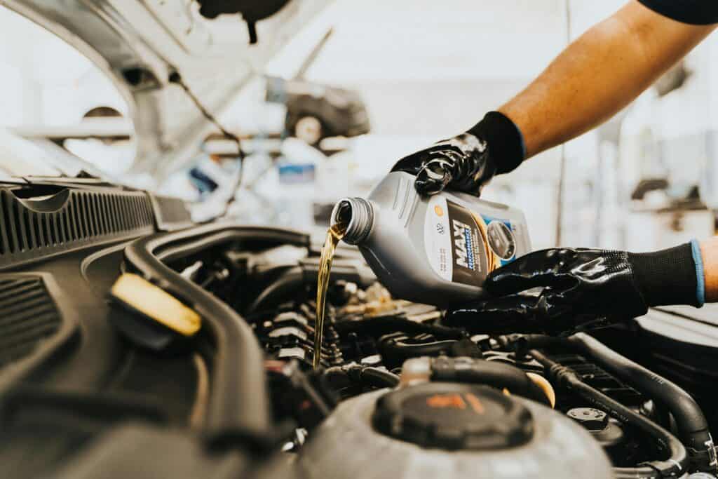 photo d'un garagiste entrain de mettre du liquide de l'huile et du refroidissement dans une voiture - mondial de l'auto 2026