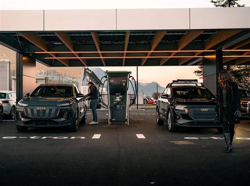 photo de la station de recharge audi charging hub a chambery en france - photos de deux personnes plan large entrain de recharger leurs voitures - mondial de l'auto 2026