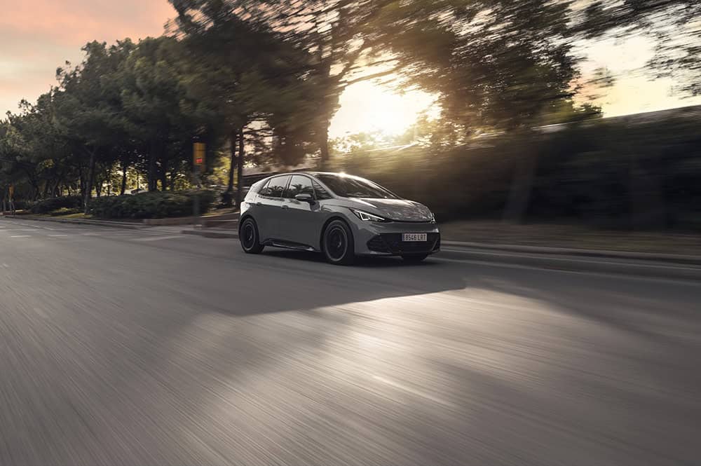 Cupra Born édition One en roulant avec couché de soleil.
